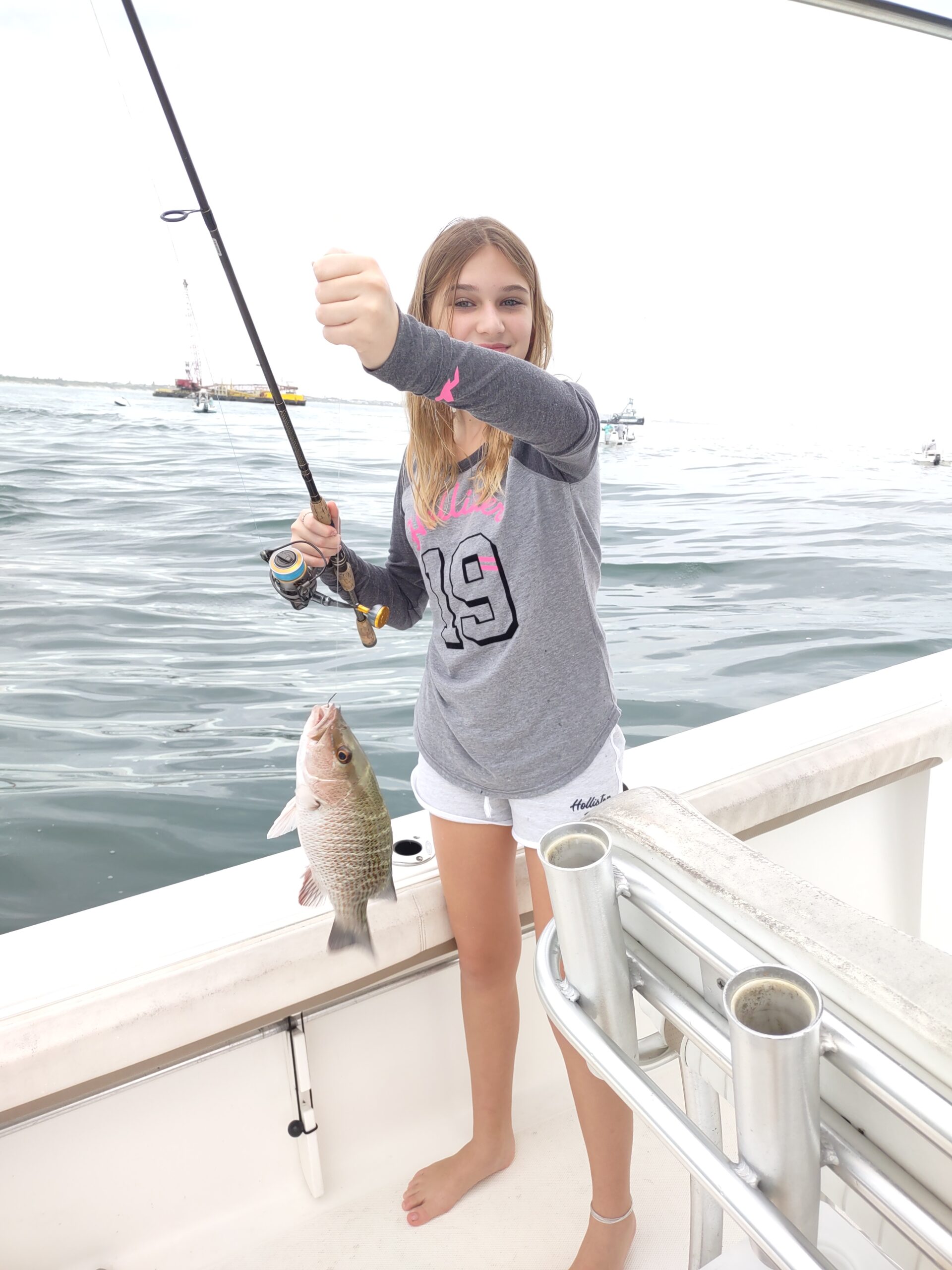 a girl holding a saltwater fish on a boat in new smyrna beach fl