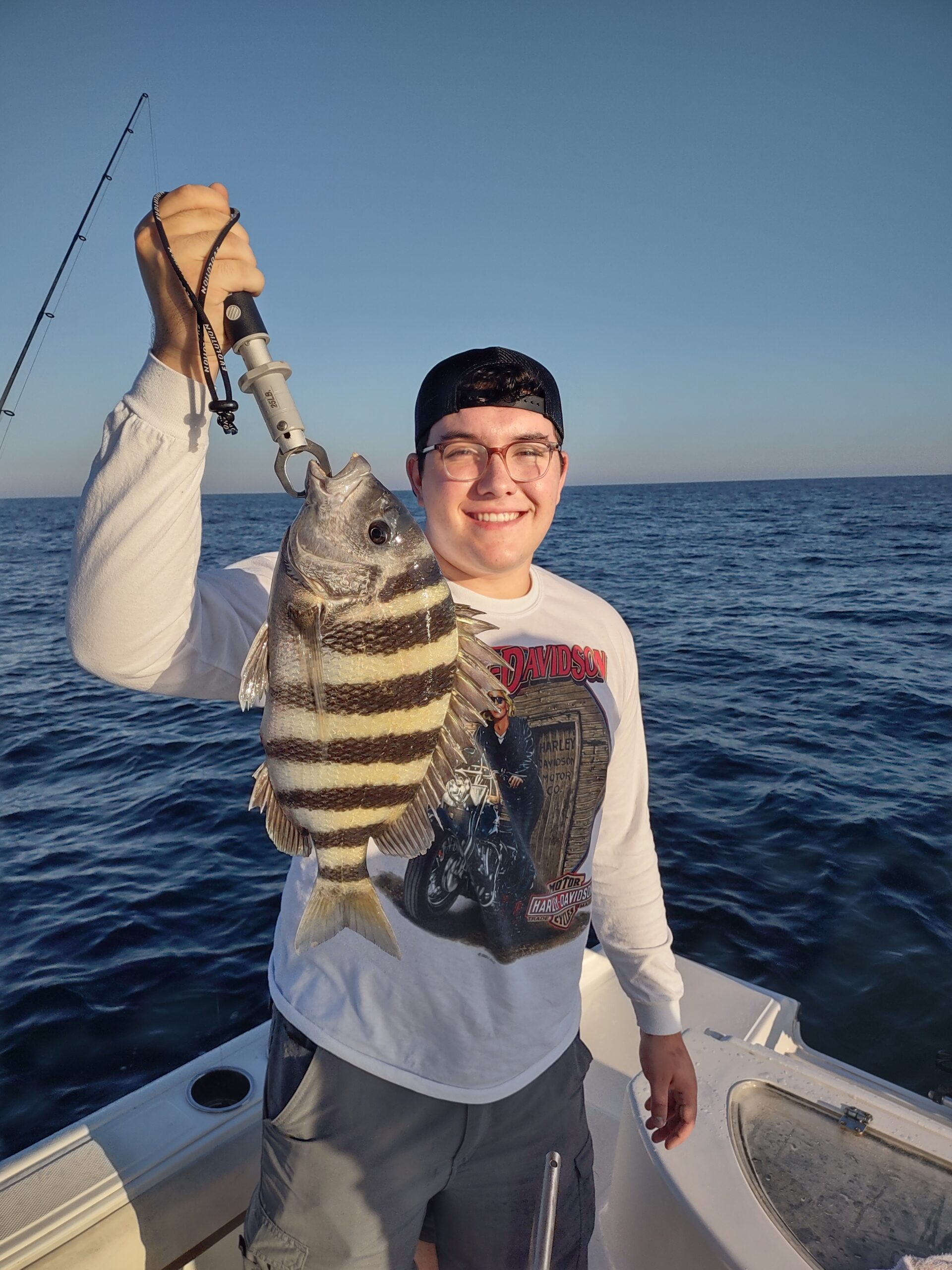 a guy holding up a sheepshead on a boat in new smyrna beach